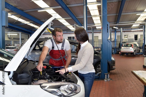 Fototapeta Customer service: car mechanic and customer discuss the repair of a vehicle on site