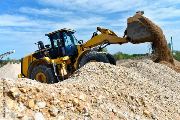 Obraz heavy construction machine in open-cast mining - wheel loader transports gravel in a gravel plant