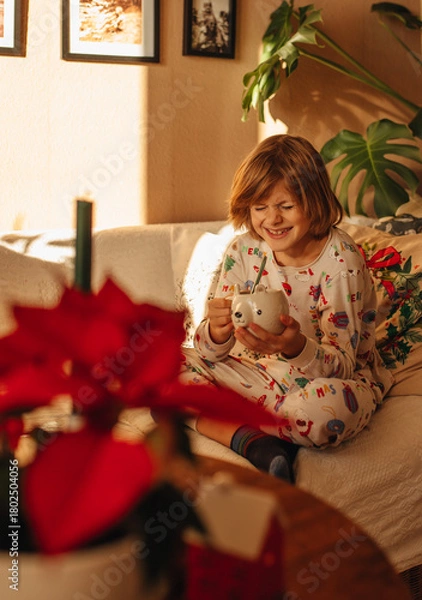 Obraz A child drinks cocoa in the morning during Christmas time