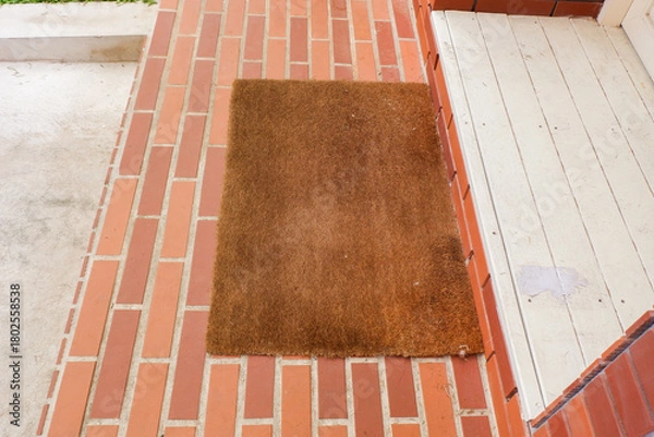 Obraz Welcome mat on red brick floor,Overhead of blank doormat at the front door,office or home,space for text.