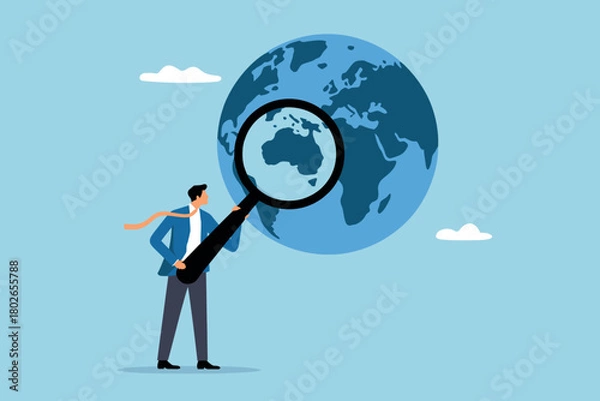 Fototapeta Businessman uses magnifying glass to study globe and discover places