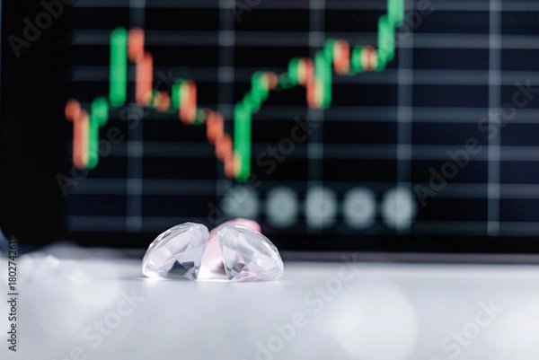Obraz Closeup of diamonds with blurred stock market graph in background