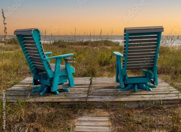 Obraz two deck chairs overlooking dunes and ocean at sunset