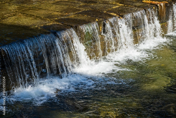 Obraz Flowing Water Curtain Over Stone Step Structure