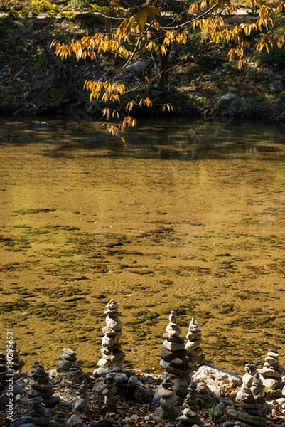 Obraz Stone Cairns beside Clear Autumn River Surface