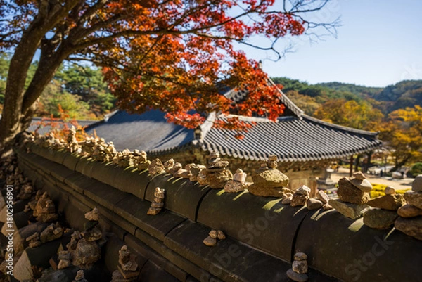 Obraz Stone Piles on Korean Tiled Wall under Autumn Foliage