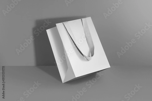 Fototapeta Mockup of a white paper bag without logo with grey handles. White package on grey background.