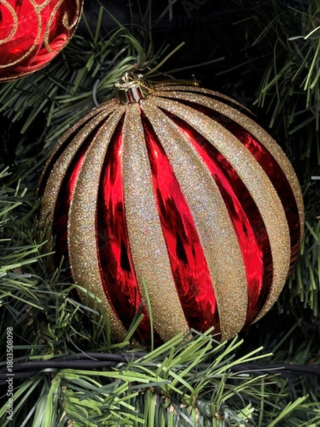 Obraz close up of red and gold striped Christmas ball on green Christmas tree