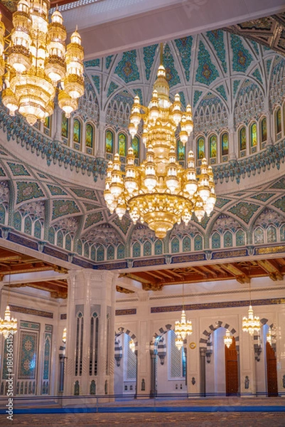 Fototapeta A stunning interior view of an Islamic mosque featuring grand golden chandeliers, an intricately patterned turquoise dome, and detailed Middle Eastern architectural elements