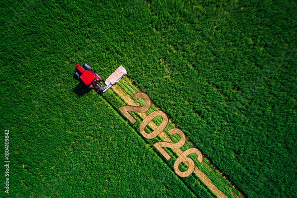 Obraz Aerial View Of Farmland Field with Working Red Tractor And Text 2026 Markings In Crops Agro background
