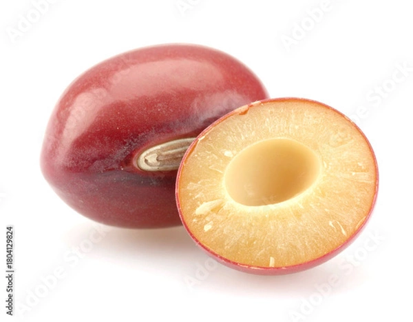 Fototapeta Ripe plums displayed sliced open on a white surface