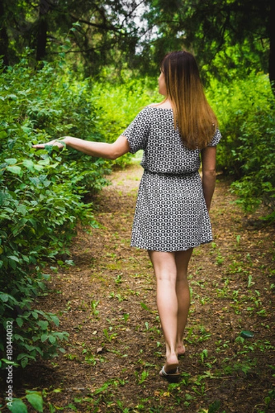 Fototapeta Девушка в платье идет по парку.