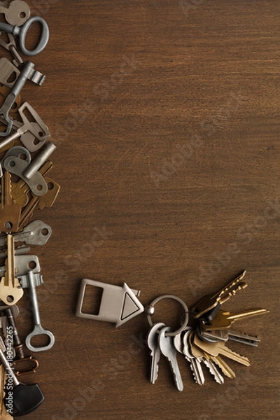 Fototapeta Bunch of keys with house trinklet on wooden table