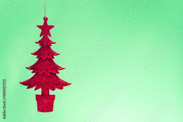 Fototapeta Sparkling red christmas tree ornament hanging against a soft green background