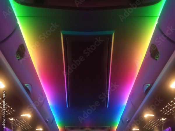 Obraz Prismatic symmetrical light patterns and a spectrum of colors create a futuristic, shimmering tunnel. Intense rainbow light creates the illusion of infinite space and energy.