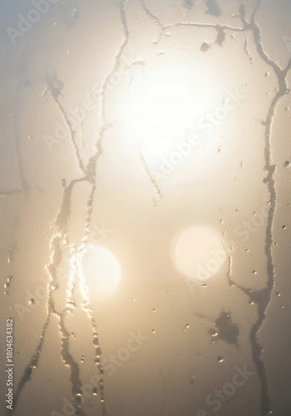 Fototapeta Abstract sunlit scene through misty glass with water droplets creating a soft, warm, atmospheric backdrop for creative projects