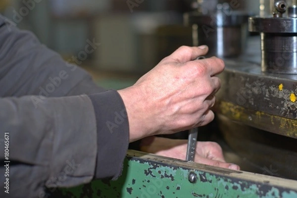 Obraz metalworking industry: factory man worker in uniform working on lathe machine in workshop