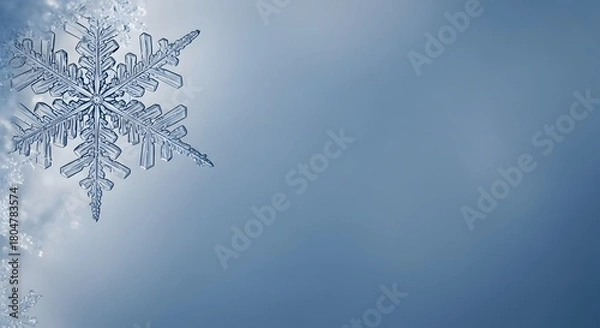 Fototapeta Close up of a delicate snowflake with intricate details on a soft blue background.