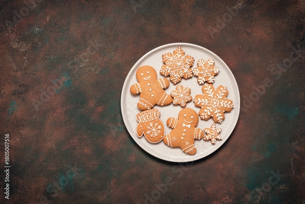 Fototapeta Christmas gingerbread cookies in a plate on dark grunge background, top view, flat lay, copy space