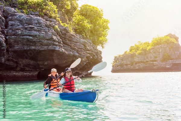 Fototapeta Two women are mother and daughter. Travel by boat with a kayak on the sea under sunlight at summer around Ko Phi, view beautiful nature of the sea, Mu Ko Ang Thong National Park, Surat Thani, Thailand