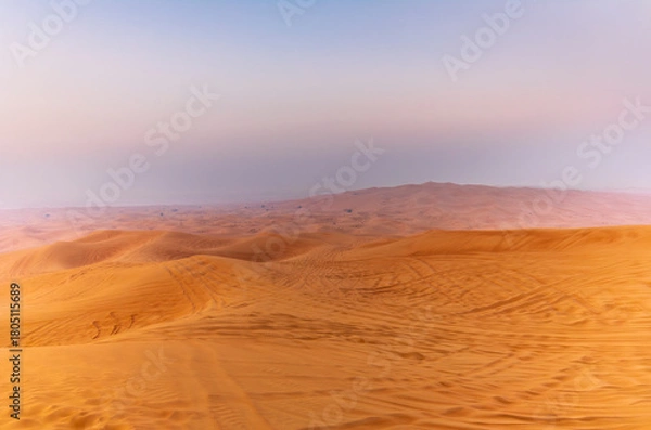 Fototapeta The sun rising on the pristine and untouched red dunes in the desert near Dubai
