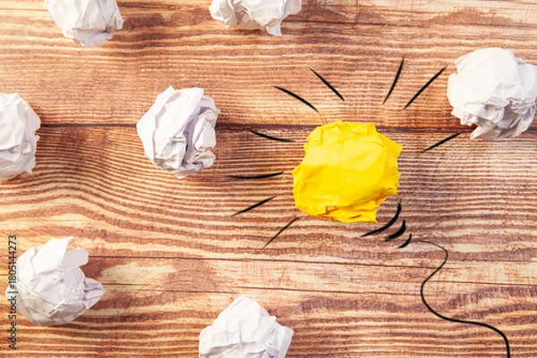Obraz Conceptual image of crumpled paper as light bulb over wooden table