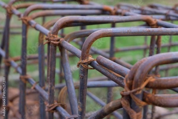 Fototapeta A close-up view of a rust-textured steel rebar frame used for house foundation construction, tightly tied with wire to form a strong structural grid.