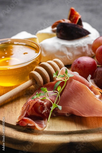 Obraz Appetizer board with meat, cheese, grapes, nuts and fresh figs.