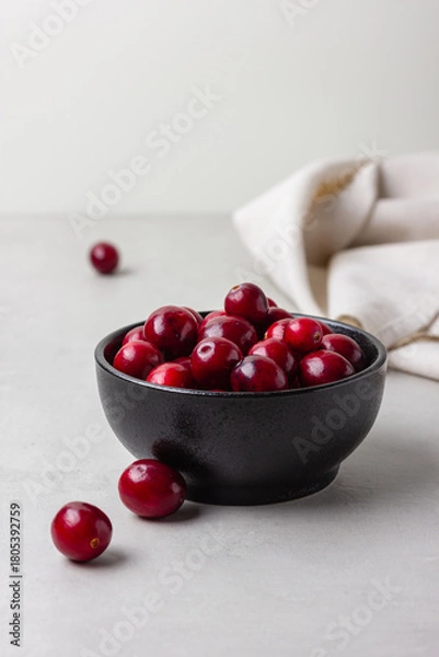 Obraz Fresh cranberries in black bowl with linen napkin