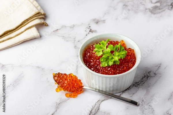 Obraz Bowl of red caviar with parsley and spoon on marble background