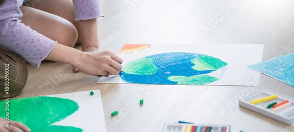 Fototapeta Group of kids hands drawing with crayons on the floor during an art activity in a bright classroom setting. Education back to school earth day concept