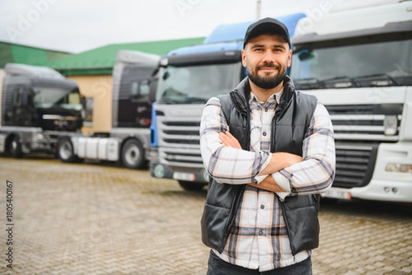 Obraz Confident truck driver standing in front of transport fleet