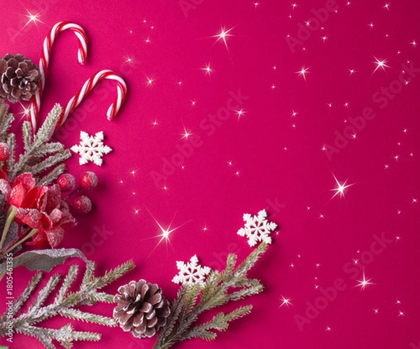 Fototapeta Christmas pink background with decorative poinsettia, fir branch and snowflakes, candy canes and cones for tree decoraton. Winter holiday composition with decor, shiny stars and copy space, top view.