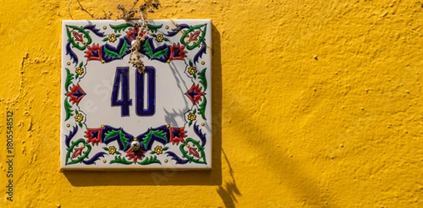 Obraz Close up of colorful ceramic house number on a yellow wall, Rhodes Old town, Greece