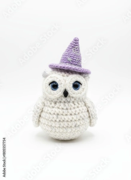Fototapeta Handmade crochet owl toy wearing a purple wizard hat on a white background, isolated and whimsical design