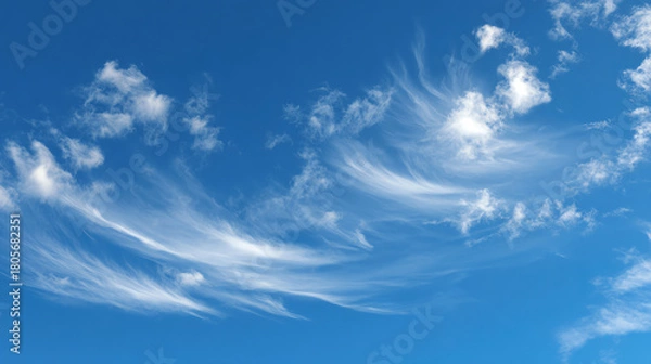 Fototapeta Beautiful wispy clouds in a bright blue sky, creating a serene and peaceful atmosphere perfect for relaxation.