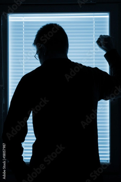 Obraz Silhouette of a man standing by the window