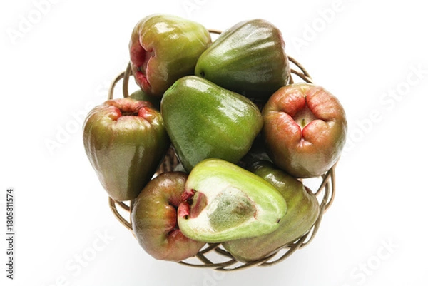 Fototapeta A basket of fresh Jambu Air Hijau (Green Water, Rose, Wax apples), with one fruit cut in half to show its crisp, white flesh against a white background.