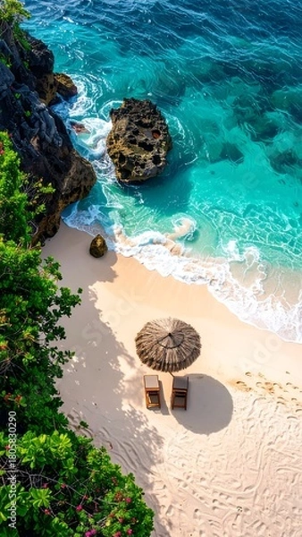 Fototapeta Aerial view of a white sand beach with clear turquoise water, dark cliffs, and tropical vegetation