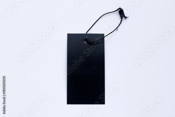 Fototapeta An overhead shot of a blank, black rectangular tag with a string, isolated on a white background.
