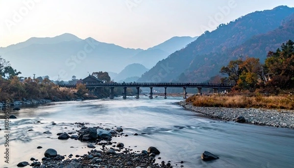 Fototapeta River Flowing Under Bridge with Mountain Backdrop.