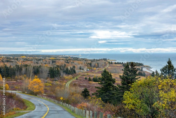 Fototapeta Stunning view of the Gaspesie Peninsula and St. Lawrence River from Chemin du Cap Bon Ami, featuring the distant Cap-des-Rosiers Lighthouse.
