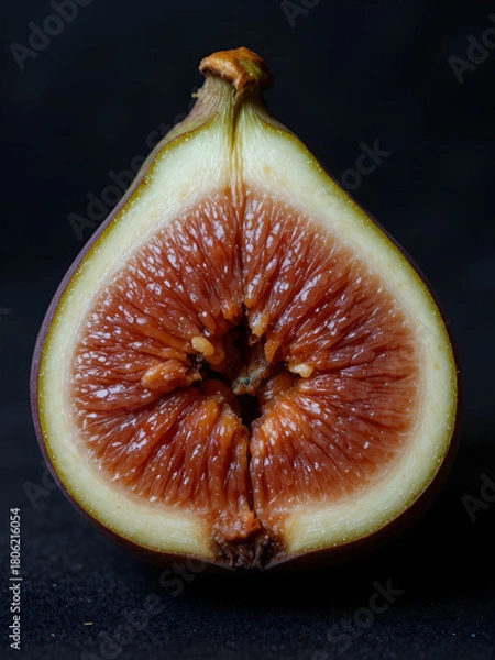 Obraz A halved fig revealing its juicy interior on a dark background