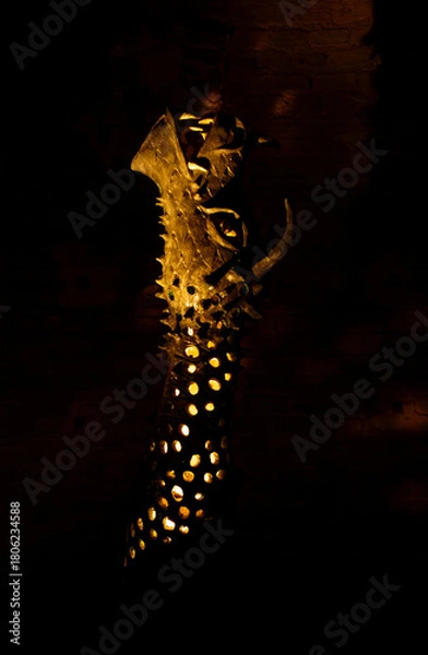 Obraz The fantasy creature statue features dark scales sharp spikes and a menacing open mouth illuminated from within