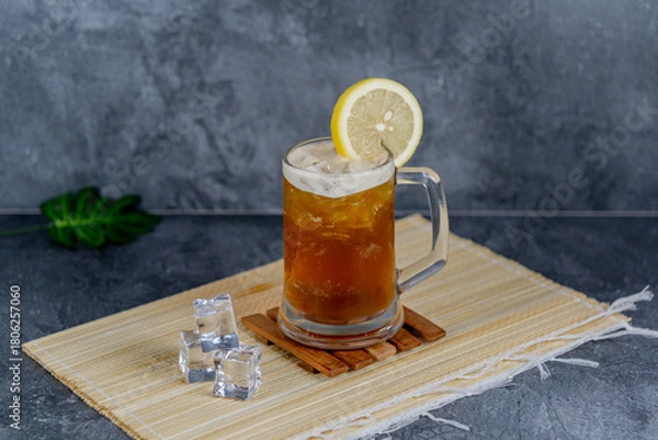 Fototapeta Lemon tea is a zesty, refreshing blend of brewed tea with fresh lemon juice and ice, often sweetened lightly. It’s tangy, thirst-quenching, and perfect as a cooling beverage for any occasion.