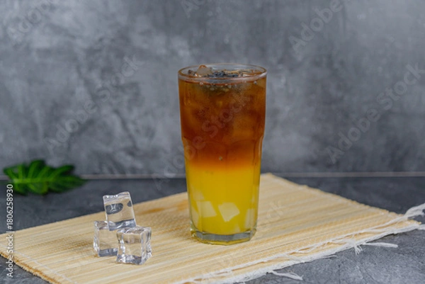 Fototapeta Orange tea is a refreshing blend of black tea and citrusy orange juice, sometimes with jelly cubes and basil seeds for extra texture. This vibrant drink offers a tangy, sweet, and cooling sensation.