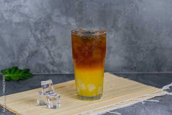 Fototapeta Orange tea is a refreshing blend of black tea and citrusy orange juice, sometimes with jelly cubes and basil seeds for extra texture. This vibrant drink offers a tangy, sweet, and cooling sensation.