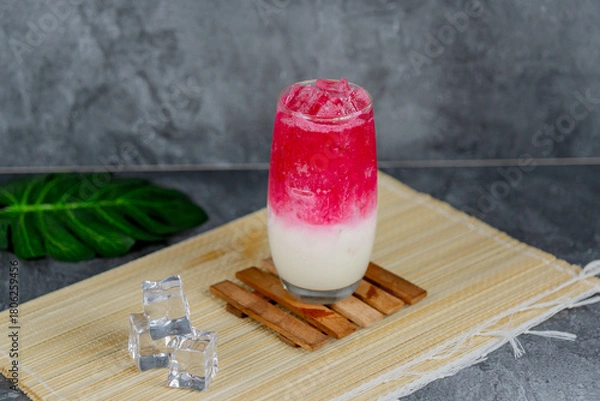 Fototapeta Red milk soda is a colorful, sweet, and creamy drink combining red syrup, milk, and soda over ice for a vibrant, fizzy refreshment. Popular at parties and loved for its unique flavor and presentation.