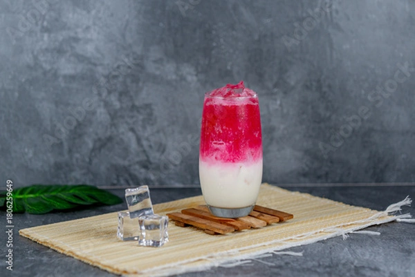 Fototapeta Red milk soda is a colorful, sweet, and creamy drink combining red syrup, milk, and soda over ice for a vibrant, fizzy refreshment. Popular at parties and loved for its unique flavor and presentation.