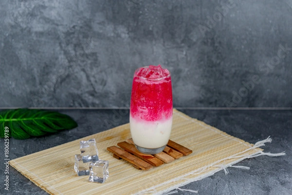 Fototapeta Red milk soda is a colorful, sweet, and creamy drink combining red syrup, milk, and soda over ice for a vibrant, fizzy refreshment. Popular at parties and loved for its unique flavor and presentation.